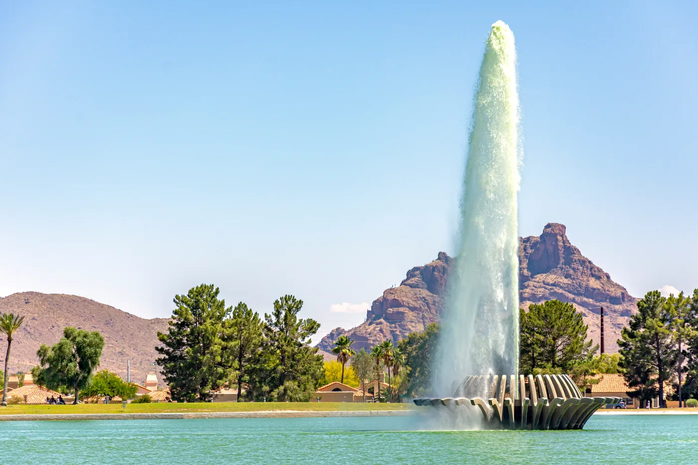 A landscaped community water feature in front of desert mountains