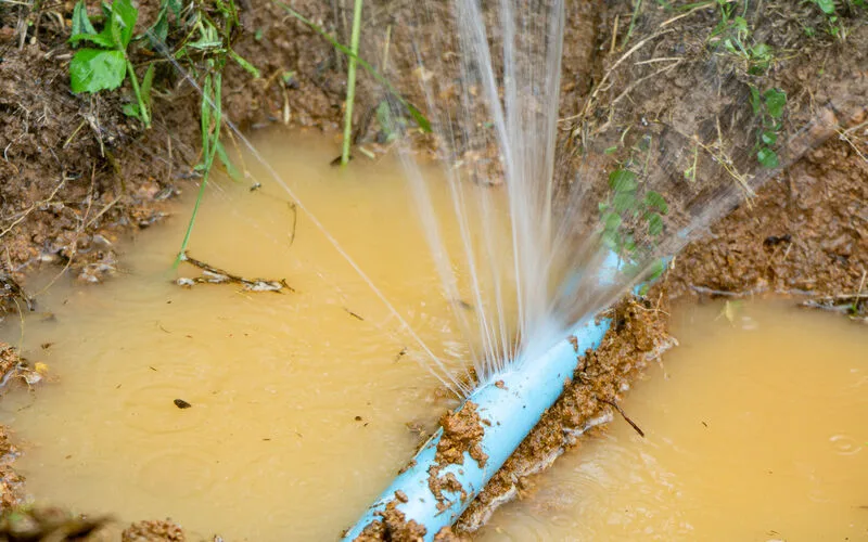 A buried water supply line exposed in a trench